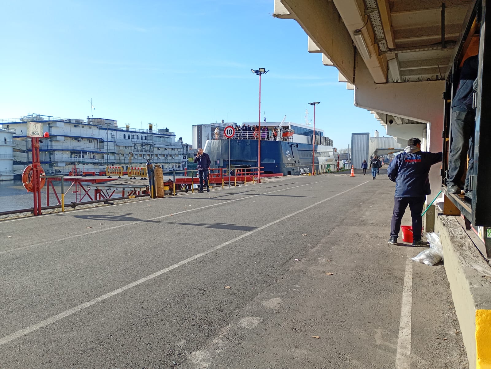 Muelle de operaciones con personal portuario y buque atracado